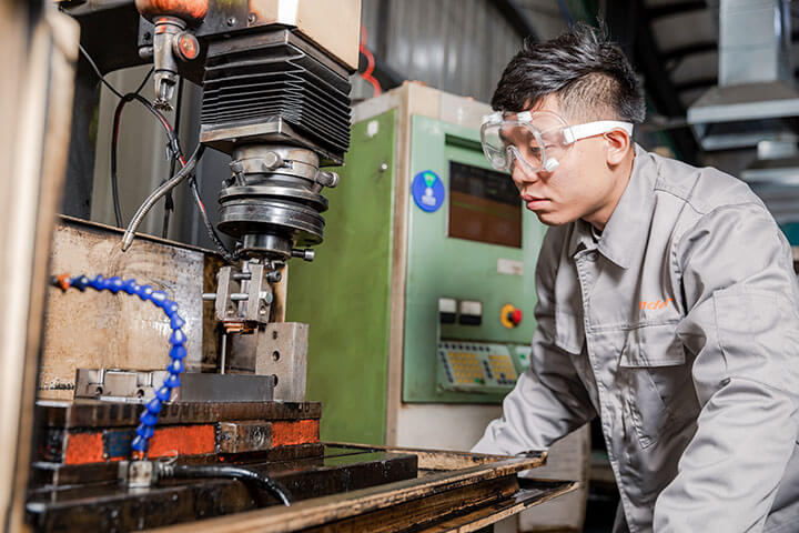 a male worker wearing safety goggles is molding a sample product