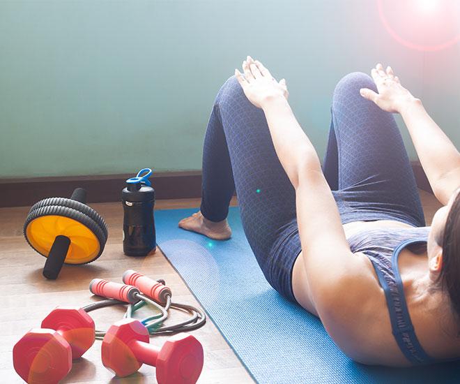 a woman is doing exercise on a yoga mat with many other fitness accessories on the floor