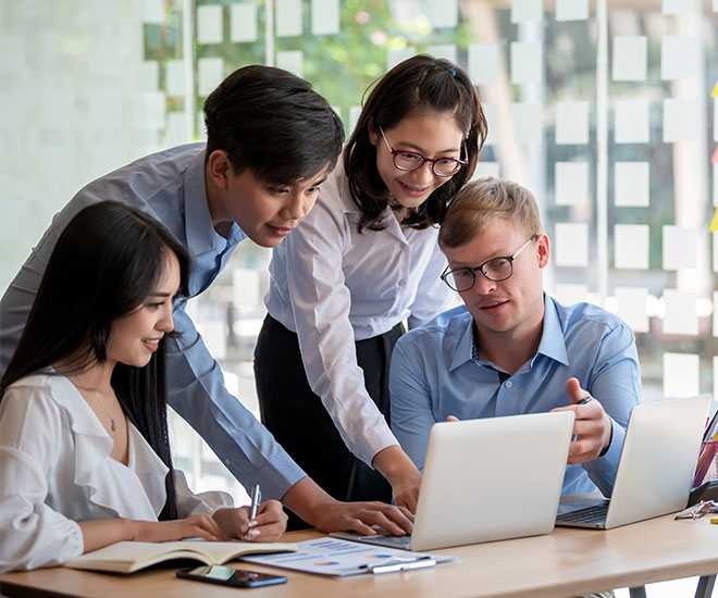 four employees are sharing their insights with two laptops on the desk