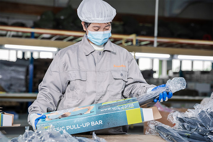 a female worker is assembling a pull-up bar