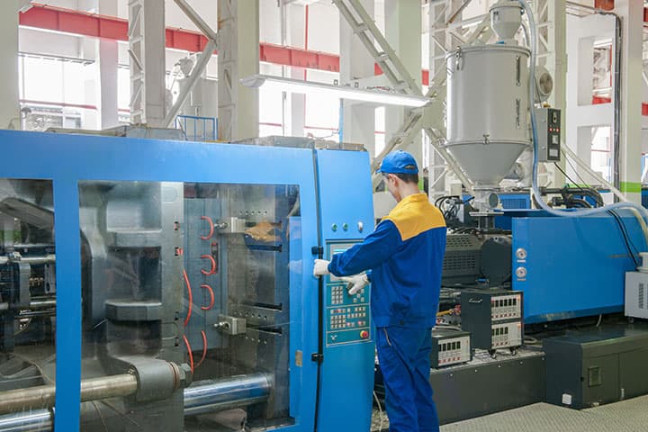 a male worker is using the injection molding machine